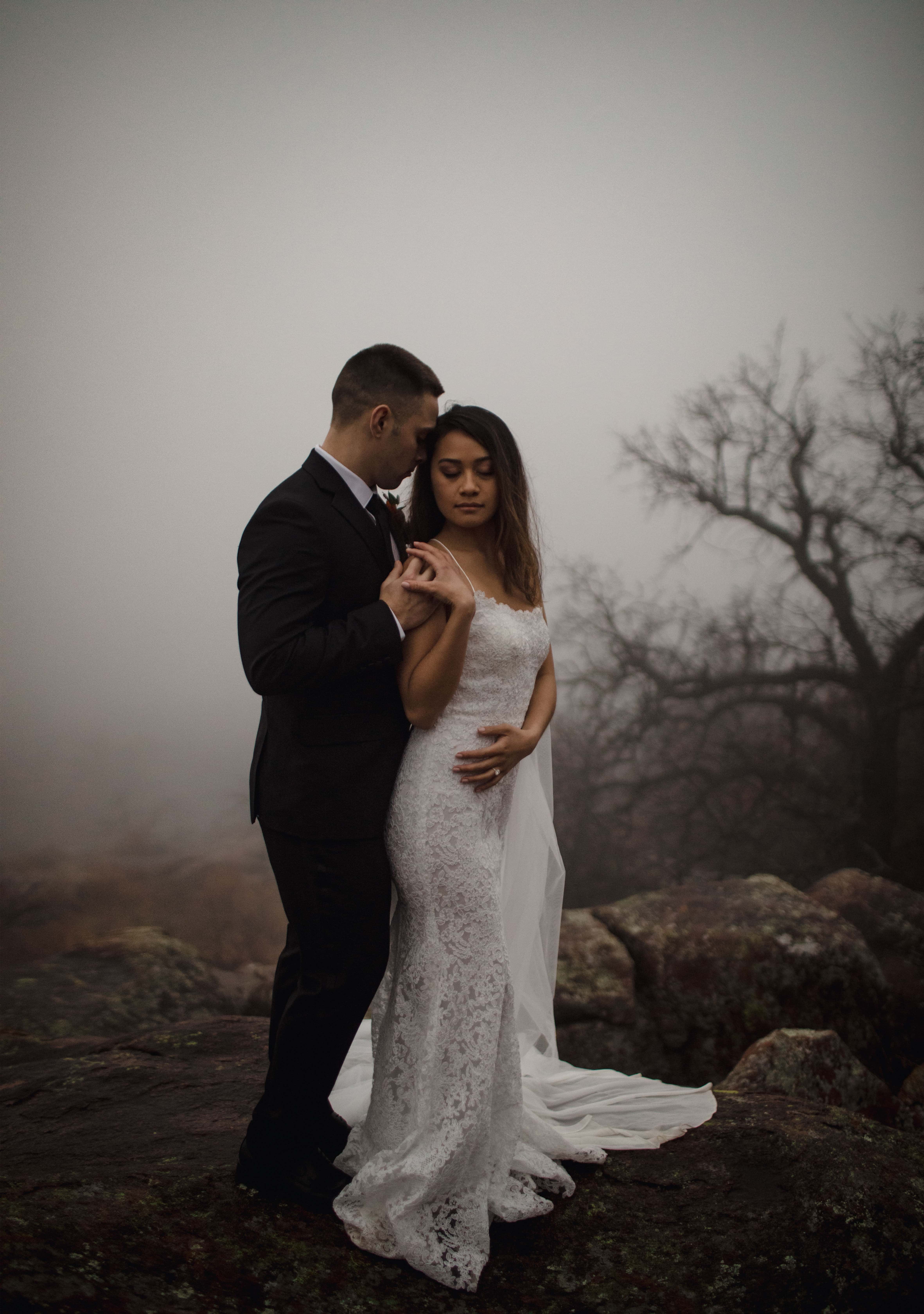 Couple posing for their Oklahoma elopement at Mount Scott in the fog.