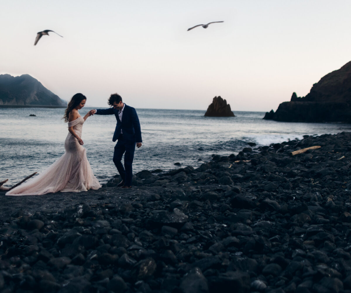 A couple on the beach posing for an Oregon elopement guide.